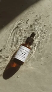 Bath Body Beyond hair serum on a softly lit surface with water ripples